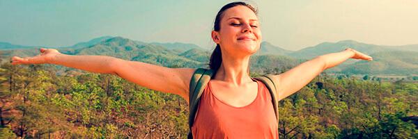 Préstamo Personal - Una chica joven con los brazos abiertos sonriendo en el monte Préstamo Personal - Una chica joven con los brazos abiertos sonriendo en el monte